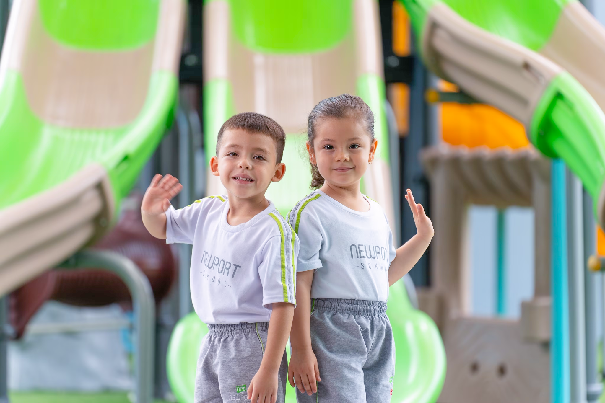 Niños sonriendo mientras saludan