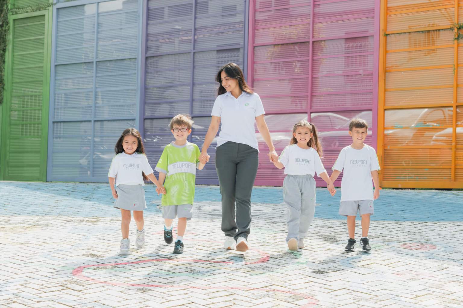 Docente con estudiantes tomados de la mano